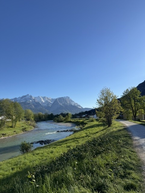 A river and gravel path leading toward the alpine ridgeline above Garmisch-Partenkirchen, Germany